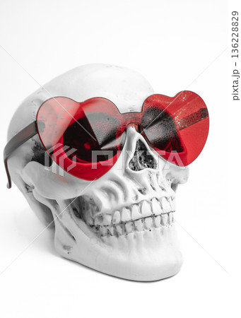Human Skull with Red Heart Shaped Sunglasses Side View on White Background Human Skull with Red Heart Shaped Sunglasses Side View on White Background 136228829