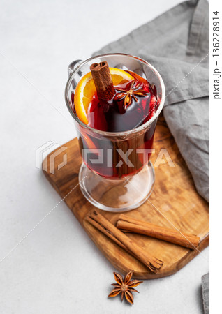Glass of mulled wine, orange, cinnamon, and star anise on a wooden board 136228914