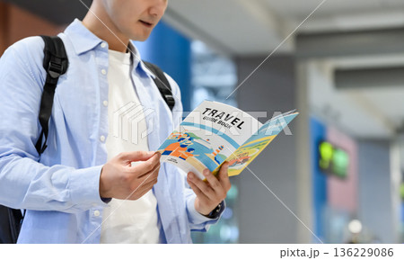 空港でガイドブックを読む男性 ■撮影協力：関西国際空港（KIX） 136229086