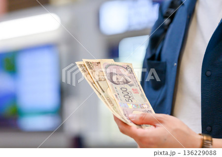 手持ちの日本円札を数える ■撮影協力：関西国際空港（KIX） 136229088