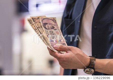 男性が日本円を数枚持つ ■撮影協力：関西国際空港（KIX） 136229096