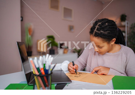 Young girl drawing on paper with markers at home Young girl drawing on paper with markers at home 136229205