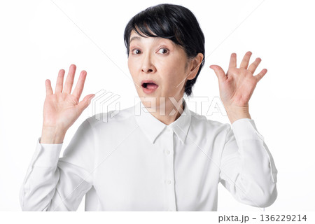 驚いた表情の白いシャツを着たショートヘアーのシニア女性 136229214
