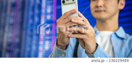 空港でスマホ撮影する男性 ■撮影協力：関西国際空港（KIX） 136229489