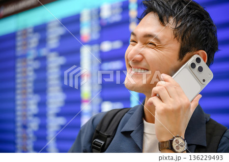 空港で電話する男性 ■撮影協力：関西国際空港（KIX） 136229493
