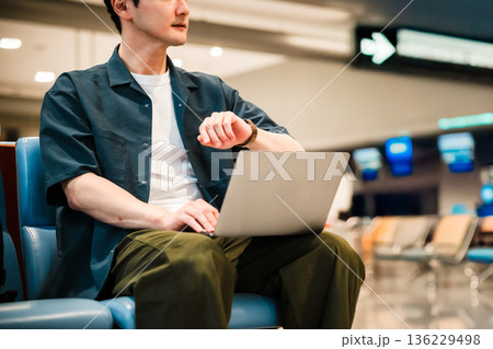 空港で時間を確認する男性 ■撮影協力：関西国際空港（KIX） 136229498