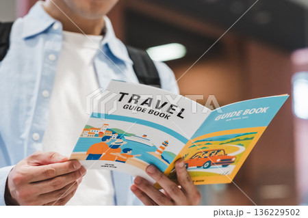 旅行ガイドブックを読む男性 _■撮影協力：関西国際空港（KIX） 136229502