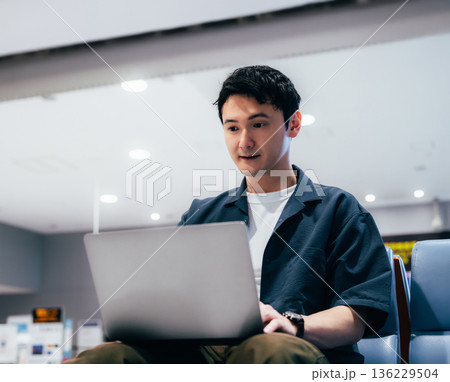 空港でPC作業する男性 ■撮影協力：関西国際空港（KIX） 136229504