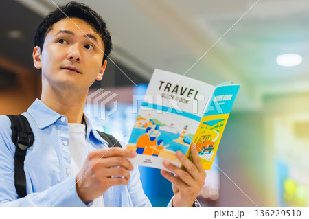 空港でガイドブックを読む男性 ■撮影協力:関西国際空港(KIX) 空港でガイドブックを読む男性 ■撮影協力:関西国際空港(KIX) 136229510