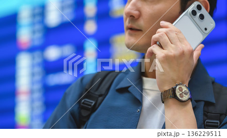 空港で電話する男性 ■撮影協力：関西国際空港（KIX） 136229511