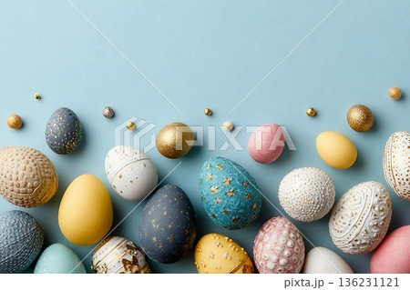 Assorted colored decorative Easter eggs laid out on a light blue surface, with various patterns and textures Assorted colored decorative Easter eggs laid out on a light blue surface, with various patterns and textures 136231121