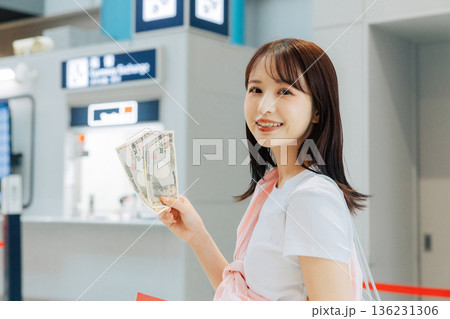 空港で両替をする女性　「撮影協力：関西国際空港（KIX）」 136231306
