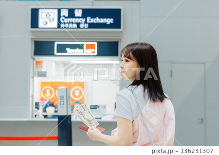 空港で両替をする女性　「撮影協力：関西国際空港（KIX）」 136231307