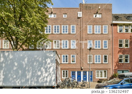 A modern urban building display features large windows and a brick facade with bicycles parked in front, embodying contemporary city life. A modern urban building display features large windows and a brick facade with bicycles parked in front, embodying contemporary city life. 136232497