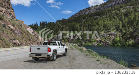 Pickup truck on the beautiful road along the mountain river and forest. Pickup truck on the beautiful road along the mountain river and forest. 136232519