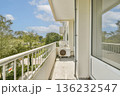 A serene balcony view showcasing natural greenery, blue skies, and a peaceful atmosphere. Perfect for relaxation and enjoying outdoor tranquility. 136232547