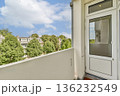 A view from a balcony showcasing a well-maintained residential area with green trees and a clear blue sky. 136232549