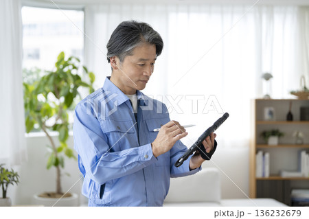 タブレットに入力するベテランの作業員 136232679