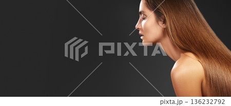 Glossy Long Brown Hair Profile Model, Salon Portrait Exuding Elegance And Sleek Texture, Studio Lighting Highlights Smooth Tresses Cascading Down Shoulder, Minimal Dark Background Focuses Attention 136232792