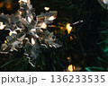 A close-up shot of an ornate cut glass snowflake hanging from a Christmas tree as a luxury xmas decoration 136233535