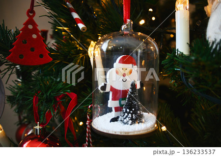 A close-up shot of a Santa encased in glass hanging Christmas tree decoration 136233537