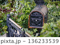 An old domestic wooden and iron mailbox in a front yard with copy space for text 136233539