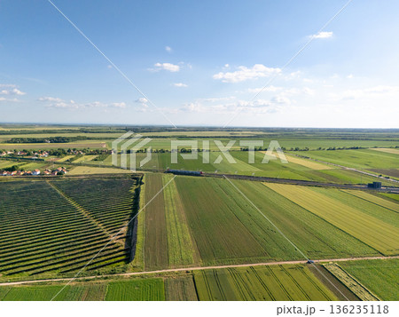 Aerial view of solar power station on a green field. Sustainable development.. 136235118
