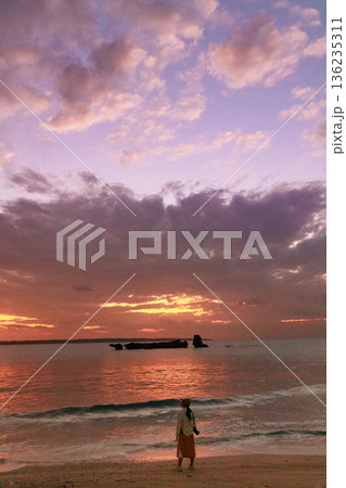 夕暮れの海を眺める女性の後ろ姿 136235311