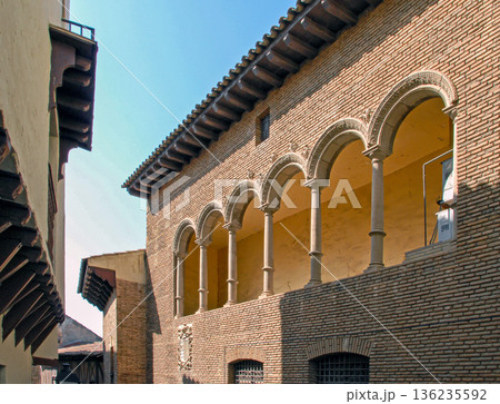 Historic building with arches located in a narrow street under blue sky 136235592