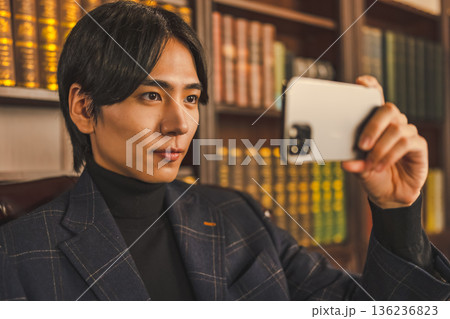 書斎でスマートフォンで自撮りをする知的でフ 書斎でスマートフォンで自撮りをする知的でフ 136236823