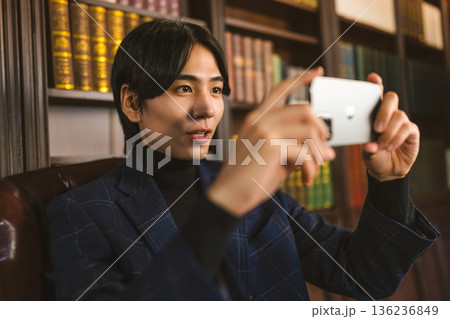 書斎でスマートフォンを使って動画を撮影する 書斎でスマートフォンを使って動画を撮影する 136236849