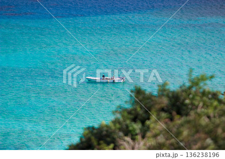 エメラルドブルーの海に浮かぶ小さな漁船 136238196