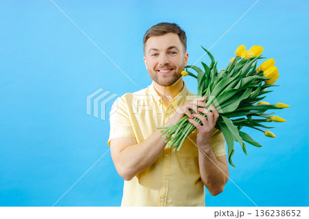 Man holding bouquet of flowers in front of face Man holding bouquet of flowers in front of face 136238652