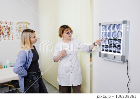 Doctor explaining spinal MRI results to patient Doctor explaining spinal MRI results to patient 136238863