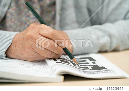 Bangkok, Thailand - May 15, 2022 elderly woman playing sudoku puzzle game. 136239434