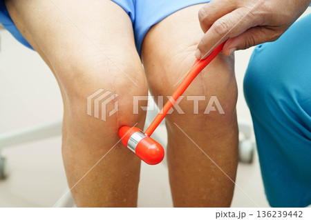 Asian doctor knock on knee reflex nerve for check and treatment senior patient in hospital. Asian doctor knock on knee reflex nerve for check and treatment senior patient in hospital. 136239442