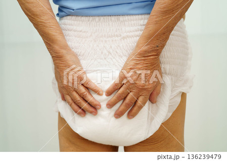 Asian senior woman patient wearing adult incontinence diaper pad in hospital. 136239479