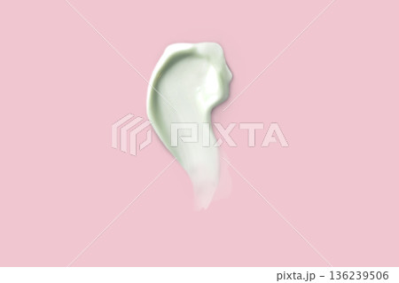 Light green Swatch sampled with a smear of cream. Face skin care, hand care, facial care. Isolated photo pink background 136239506