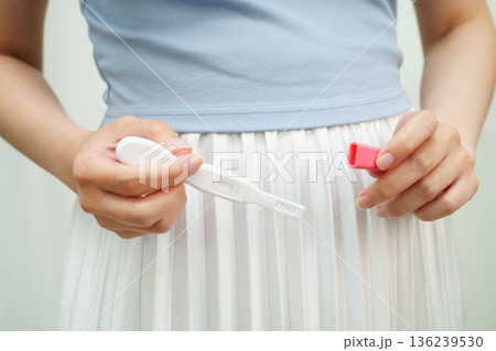 Asian holding pregnancy test for female of ovulation day, fetus, maternity, childbirth, birth control. 136239530