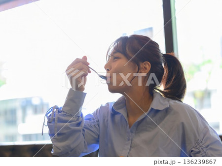 カフェでデザートをスプーンで食べる横顔の若 136239867