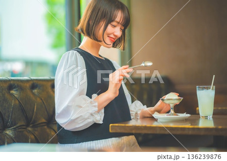 カフェでアイスクリームを楽しむ若い女性 カフェでアイスクリームを楽しむ若い女性 136239876