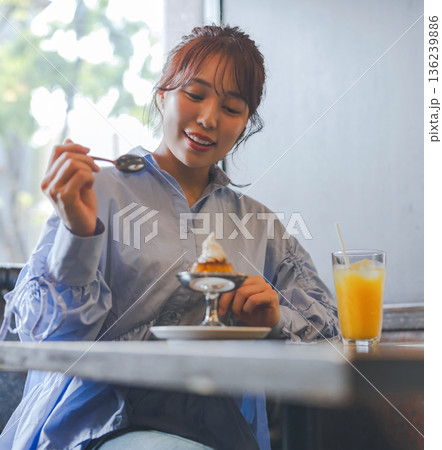 カフェでプリンアラモードを食べるアジア人女性 136239886