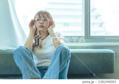 窓際で考え事をする女性 136240083
