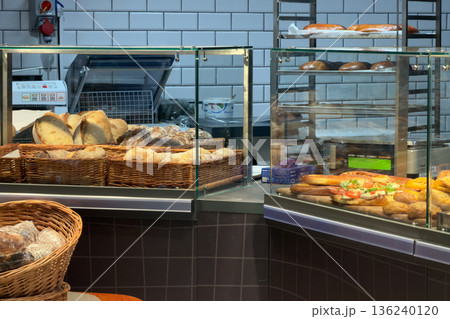 Vibrant bakery display case showcasing fresh artisanal bread loaves, diverse gourmet sandwiches, and a prominent container of cottage cheese, emphasizing daily food retail Vibrant bakery display case showcasing fresh artisanal bread loaves, diverse gourmet sandwiches, and a prominent container of cottage cheese, emphasizing daily food retail 136240120