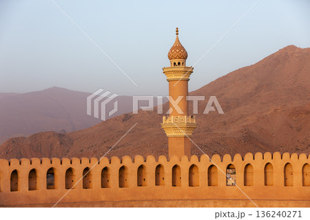 Nizwa Fort walls and Al Qalaa Mosque in afternoon light in Oman 136240271