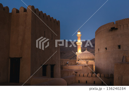 Nizwa Fort tower and Al Qalaa Mosque illuminated at night in Oman Nizwa Fort tower and Al Qalaa Mosque illuminated at night in Oman 136240284