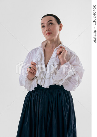 Classic woman in white ruffled blouse posing in studio portrait. Classic woman in white ruffled blouse posing in studio portrait. 136240450