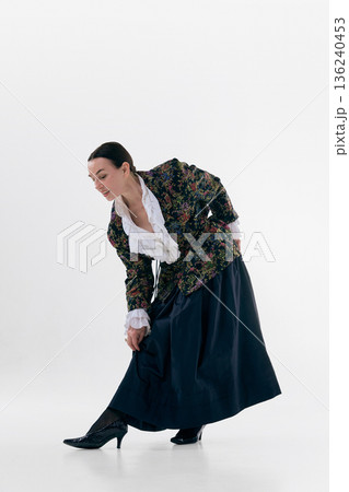 Elegant mature woman bending forward in floral jacket with playful natural emotion. 136240453