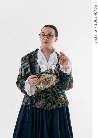Elegant mature poetcore woman holding vintage purse. 136240455