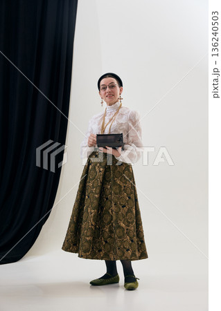 Vintage poetcore woman holding notebook in studio portrait with thoughtful calm. Vintage poetcore woman holding notebook in studio portrait with thoughtful calm. 136240503